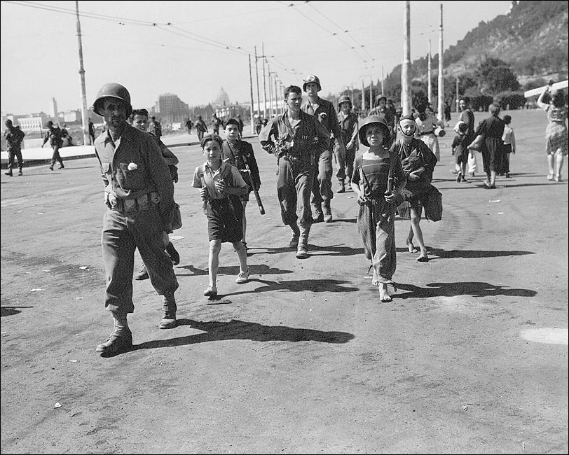 Bambini romani aiutano i soldati americani a portare l'equipaggiamento, 1944